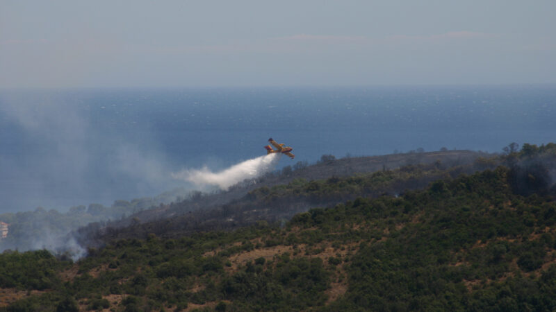 Avion de stingere lansând apă peste un incendiu de vegetație, în sudul Franței
