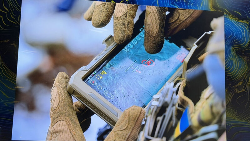 Mâinile înmănușate ale unui militar pe un dispozitiv portabil care afișează o imagine satelitară cu ținte marcate. Foto: SpaceNews