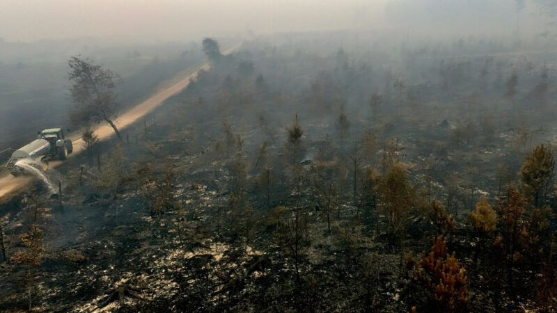 Vegetație arsă și un utilaj agricol stropind cu apă în rezervația Hautes Fagnes, Belgia. Foto: Reuters via Al Jazeera
