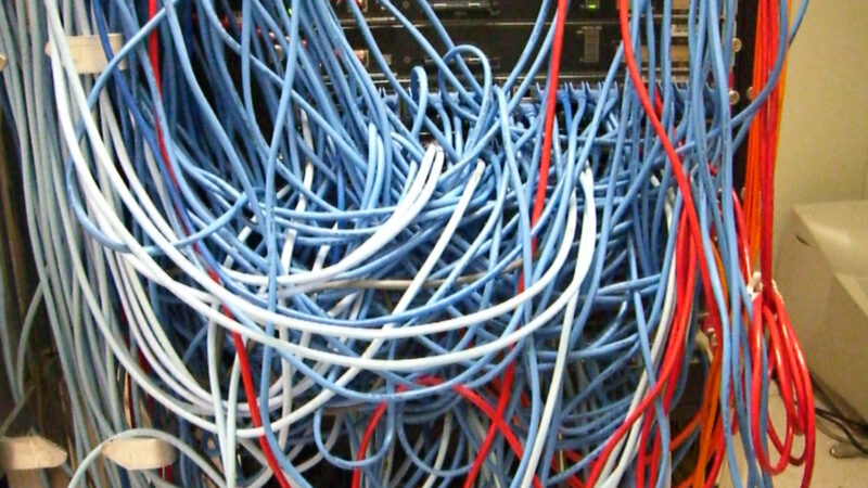 Mănunchi dens de cabluri de rețea într-un rack de servere