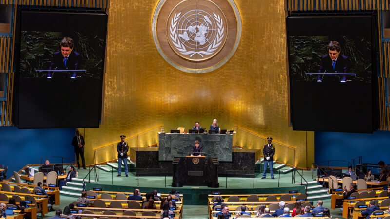 Nicușor Dan vorbind la tribuna Adunării Generale a ONU, cu imaginea sa pe ecranele din sală
