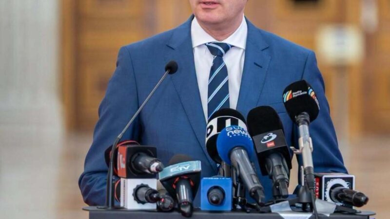 Siegfried Mureșan face declarații de presă la un pupitru cu microfoane, în Palatul Parlamentului