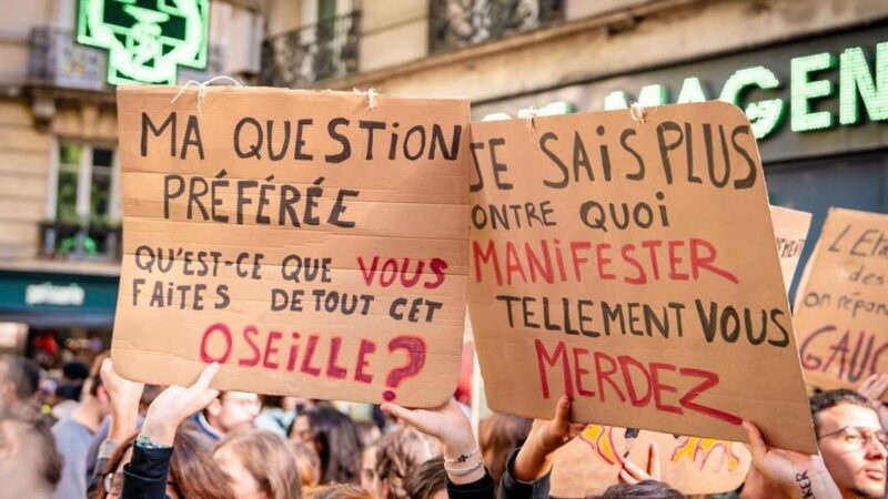 Tineri cu pancarte la manifestația de la Paris din 17 octombrie